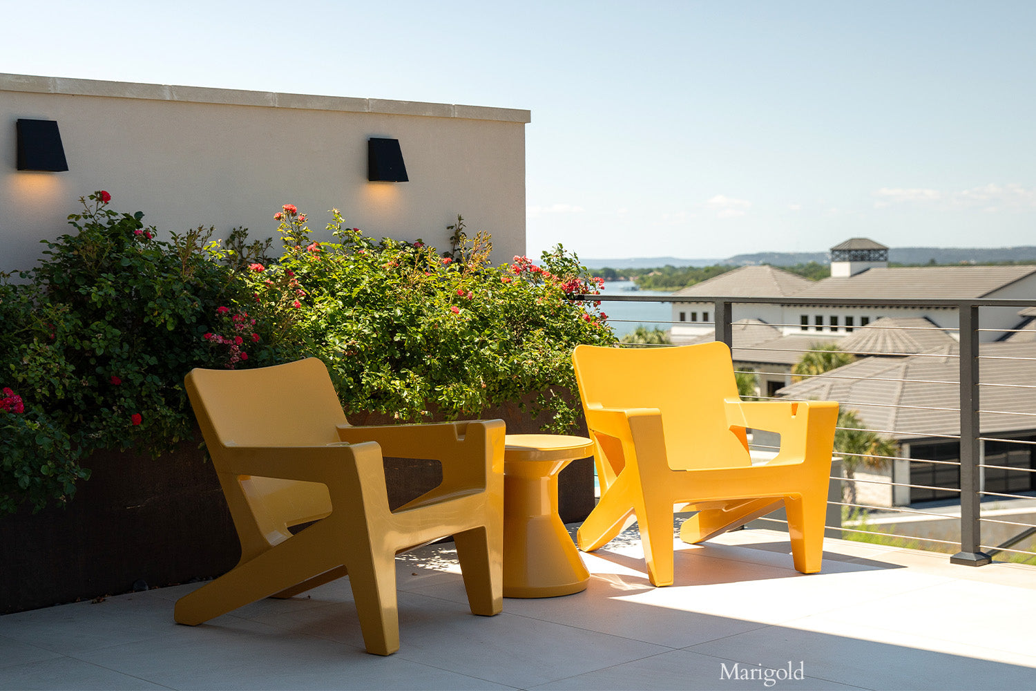 Tupelo Bask Chair Marigold on a patio overlooking the lake