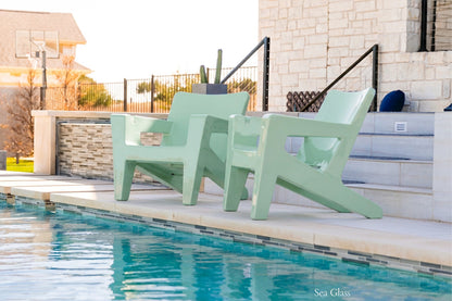 Tupelo Bask Chair Sea Glass sitting by a backyard pool