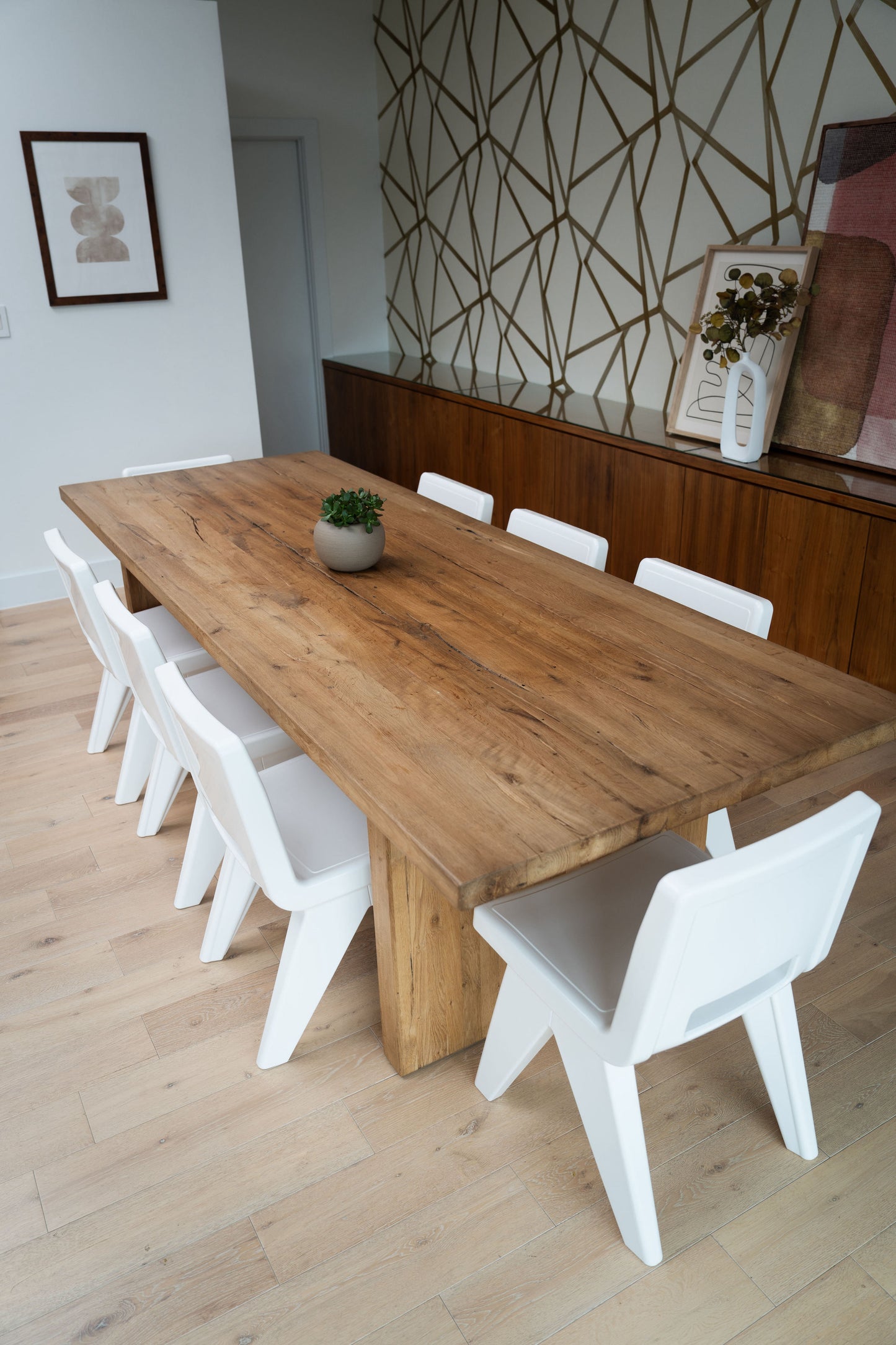 Image of 8 modern Highcloud White Fresco Dining Chairs from marine-grade polyethylene around a wooden indoor dining table. 