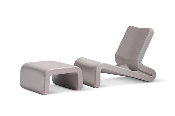 Image shows a Sandstone Line Lounge chair paired with the Sandstone Ottoman made with resin, in front of a white background.