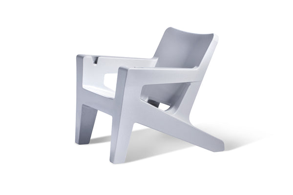 Image of an angled view of the Bask Lounge Chair in the color Concrete Grey, made with resin, displayed on a white background.