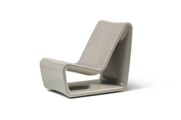Image of an angled side view of the modern Sandstone Loop Lounge Chair made with polyethylene, shown on a white background.
