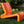 This image shows the Vintage Orange Line Lounge Chair made of premium polyethylene resin, displayed on an outdoor background.